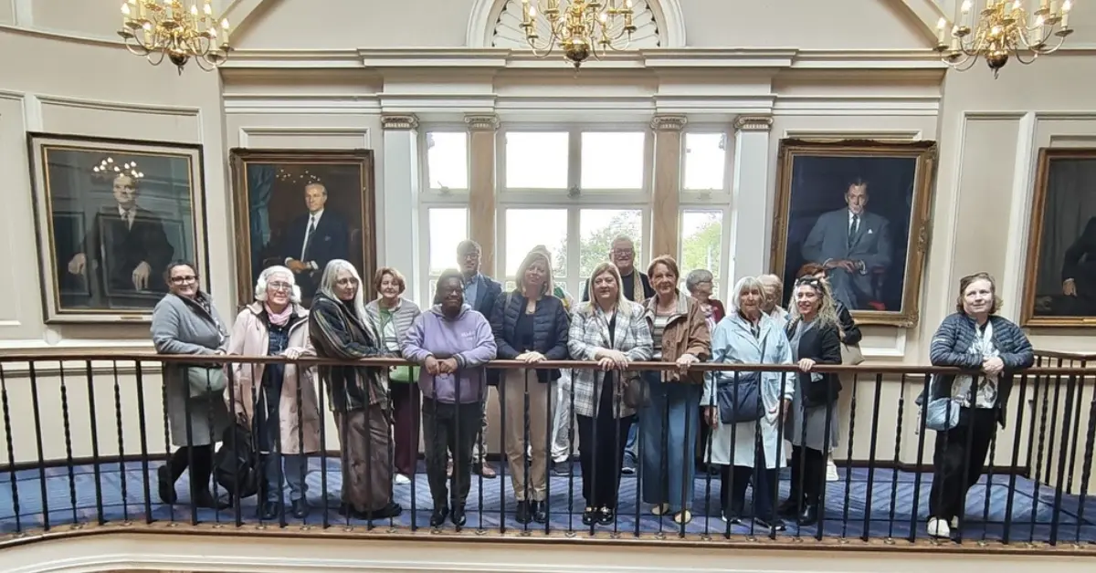 PPN members standing on an upper-level balcony inside Leinster House, surrounded by portraits of Irish leaders.